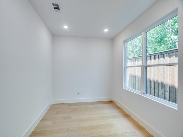empty room with recessed lighting, baseboards, light wood-style floors, and visible vents