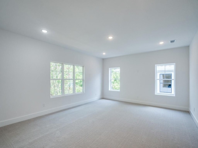 unfurnished room with visible vents, baseboards, light colored carpet, and recessed lighting