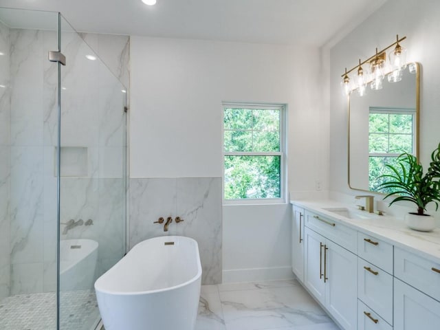 bathroom with marble finish floor, a freestanding tub, a marble finish shower, and a healthy amount of sunlight