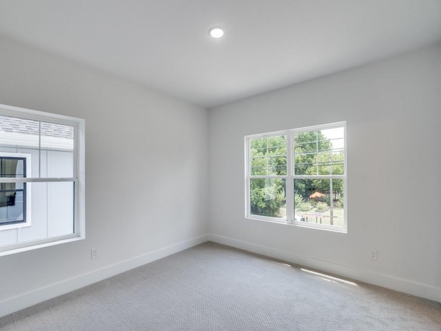 carpeted spare room featuring baseboards and recessed lighting