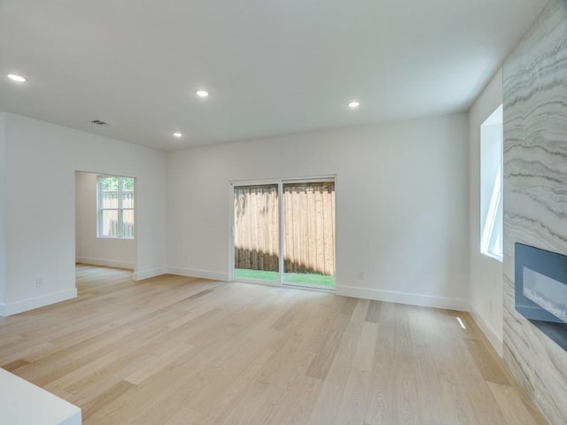 unfurnished living room featuring light wood-style flooring, baseboards, and recessed lighting
