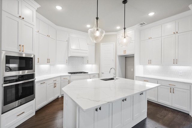 kitchen with built in microwave, a sink, stainless steel oven, decorative backsplash, and gas stovetop