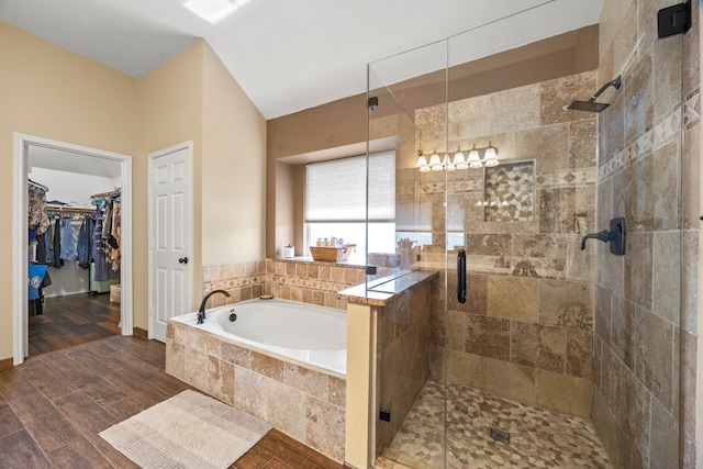 7113 Raintree Way, Denton, TX 76210 - bathroom featuring wood finished floors, a bath, a walk in closet, and a stall shower