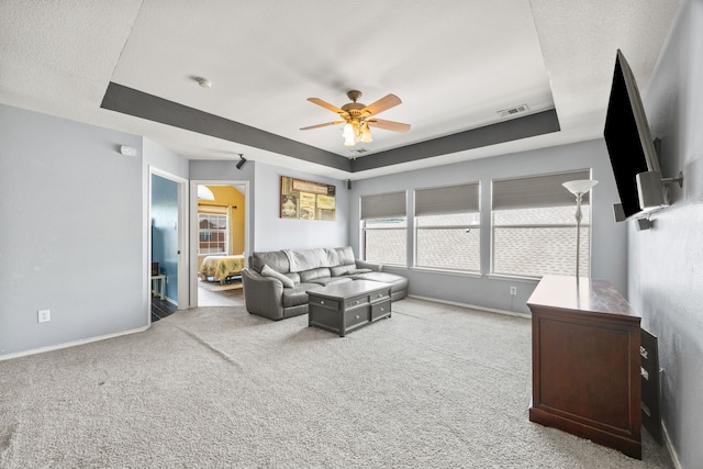 7113 Raintree Way, Denton, TX 76210 - living area with ceiling fan, visible vents, a raised ceiling, baseboards, and carpet