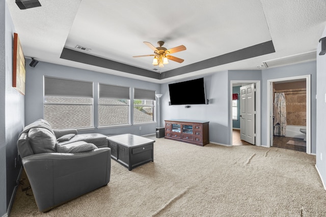 7113 Raintree Way, Denton, TX 76210 - carpeted living room featuring visible vents, baseboards, ceiling fan, and a tray ceiling