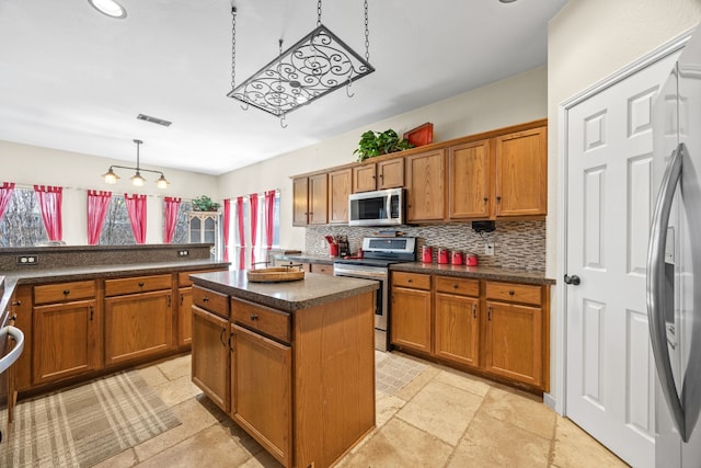 7113 Raintree Way, Denton, TX 76210 - kitchen featuring decorative backsplash, a kitchen island, visible vents, appliances with stainless steel finishes, and brown cabinets