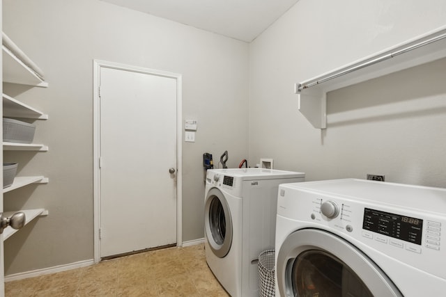 clothes washing area featuring washer and clothes dryer, laundry area, and baseboards