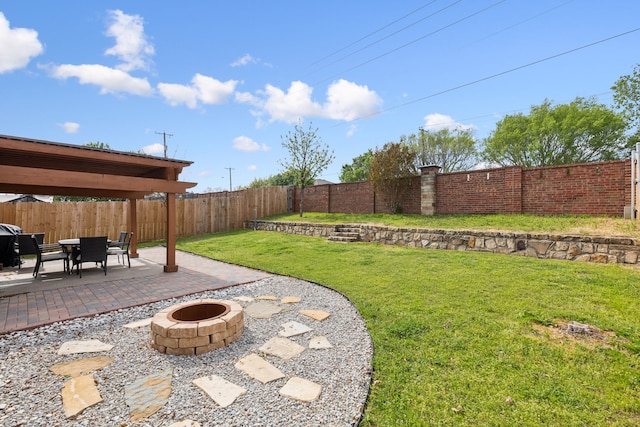 view of yard featuring a fenced backyard, a fire pit, and a patio area