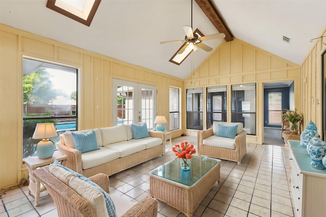 sunroom / solarium featuring a skylight, beam ceiling, tile patterned floors, french doors, and high vaulted ceiling
