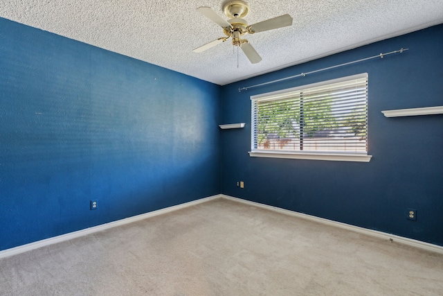 carpeted empty room with a textured ceiling, ceiling fan, and baseboards