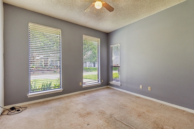 spare room featuring ceiling fan, carpet flooring, baseboards, and a textured ceiling