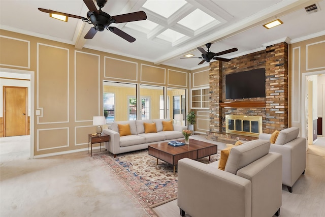 living area featuring a decorative wall, ceiling fan, crown molding, beam ceiling, and a fireplace