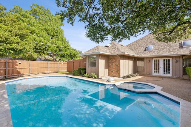 view of pool featuring french doors, a fenced backyard, and a pool with connected hot tub
