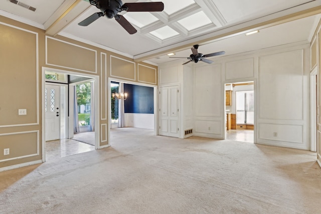 unfurnished living room featuring a decorative wall, a ceiling fan, carpet floors, beam ceiling, and coffered ceiling
