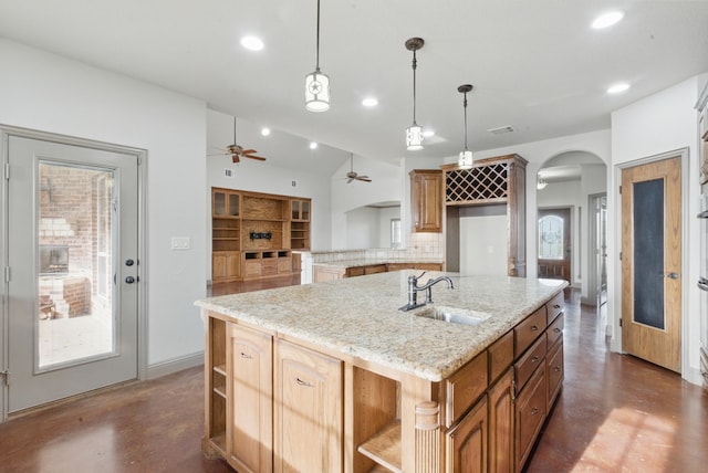 kitchen featuring arched walkways, concrete floors, ceiling fan, and open shelves