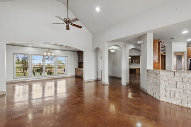 unfurnished living room with baseboards, arched walkways, and ceiling fan with notable chandelier