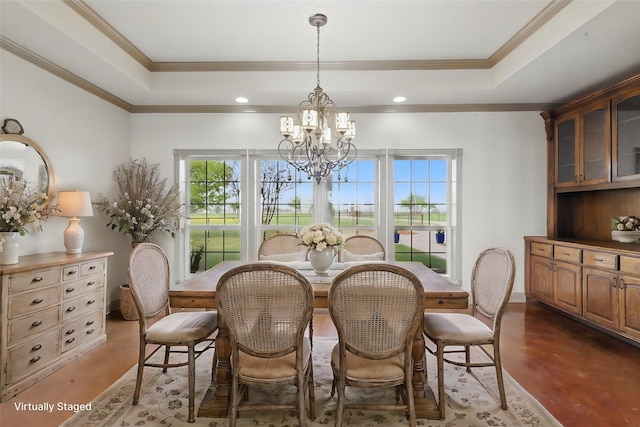 dining room featuring a tray ceiling, a notable chandelier, and crown molding