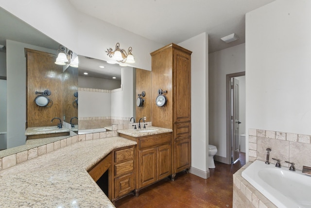 bathroom with a bath, baseboards, double vanity, toilet, and a sink