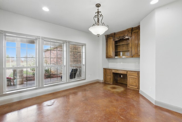 interior space with built in desk, concrete floors, baseboards, and recessed lighting