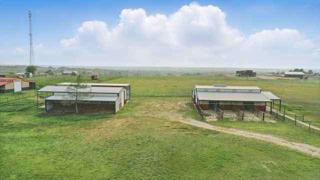 view of yard featuring an outdoor structure, an exterior structure, and a rural view