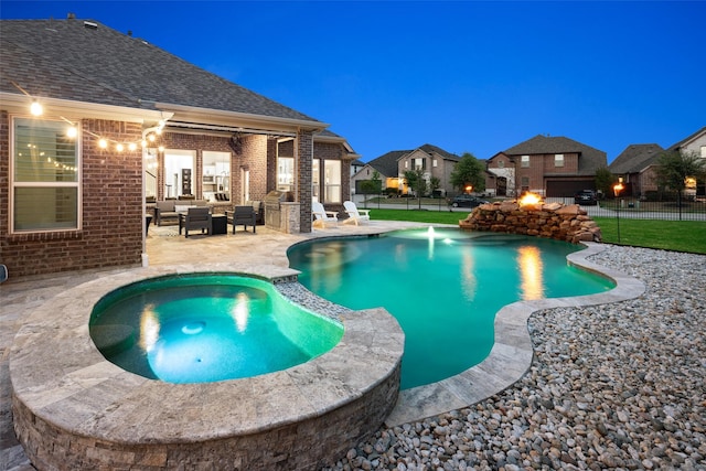view of swimming pool with a patio, a pool with connected hot tub, a fenced backyard, and an outdoor living space with a fire pit