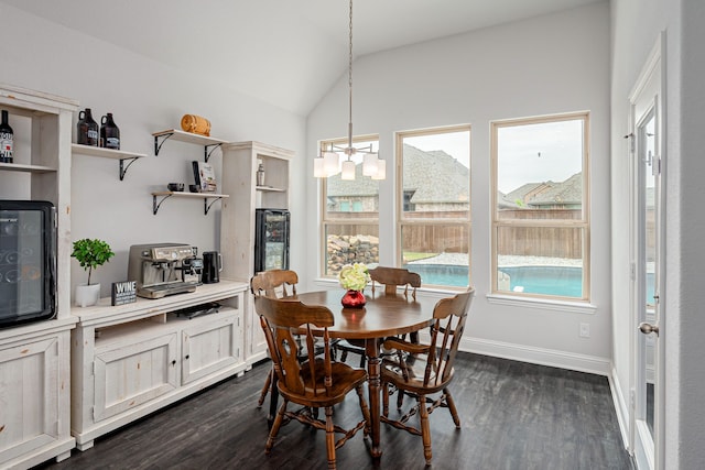 dining room with baseboards, dark wood-type flooring, lofted ceiling, and a notable chandelier
