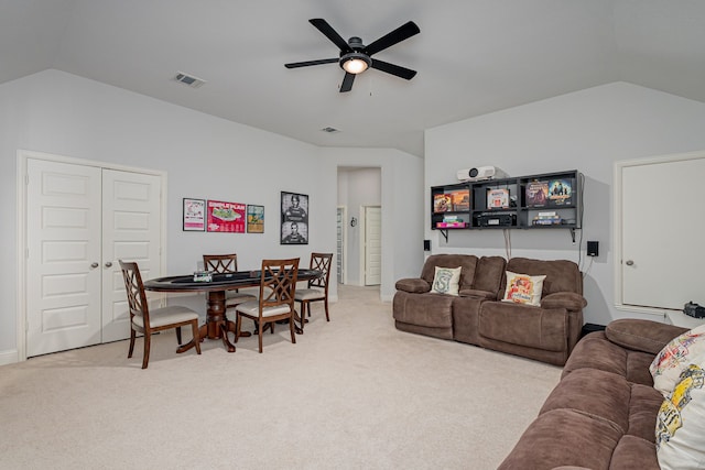 living room with carpet floors, a ceiling fan, visible vents, and vaulted ceiling
