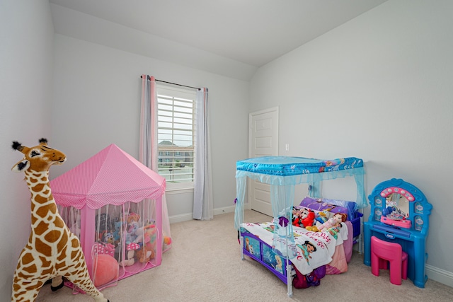 carpeted bedroom with baseboards and lofted ceiling