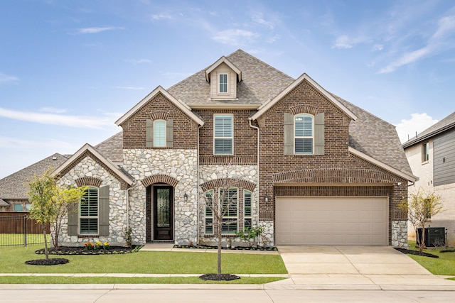 view of front of property with fence, driveway, brick siding, and stone siding