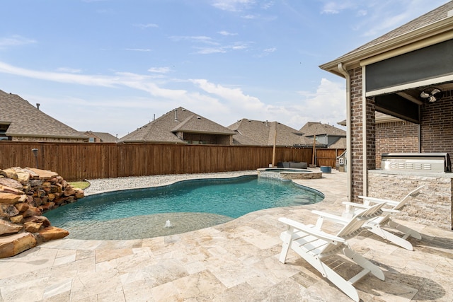 view of swimming pool with area for grilling, a pool with connected hot tub, a fenced backyard, and a patio area
