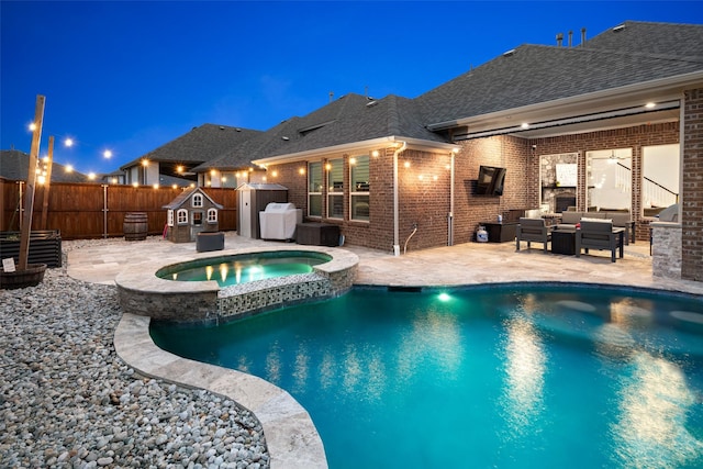 view of pool featuring outdoor lounge area, a fenced backyard, a patio area, and a storage unit