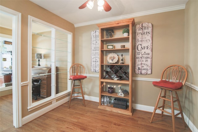 dining area with baseboards, ceiling fan, wood finished floors, and crown molding