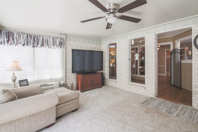 carpeted living area with a wall unit AC, ceiling fan, and brick wall