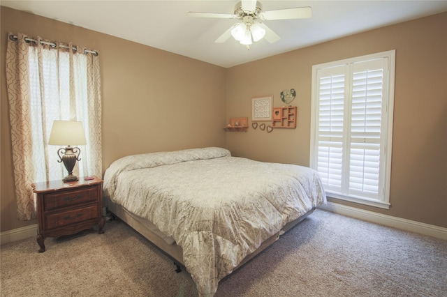 bedroom featuring baseboards, a ceiling fan, and light colored carpet