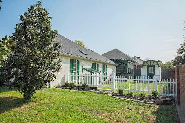 view of front of property with a shingled roof, fence, and a front lawn