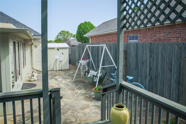 view of patio with a fenced backyard, an outbuilding, and a storage shed