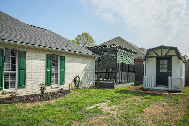 view of yard featuring a storage unit, an outbuilding, fence, and a pergola