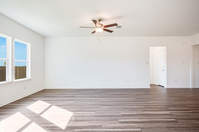 unfurnished room with baseboards, ceiling fan, visible vents, and wood finished floors