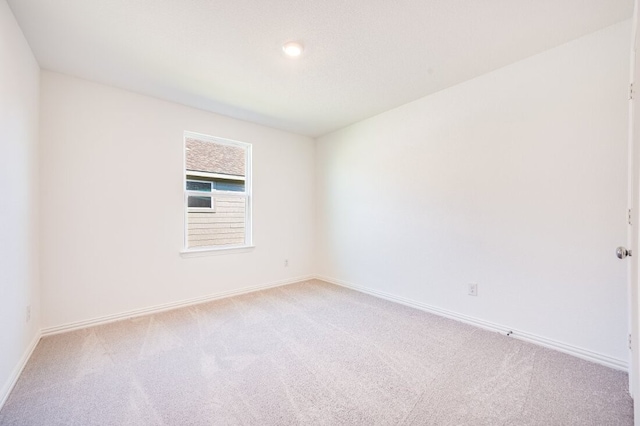 carpeted empty room with baseboards