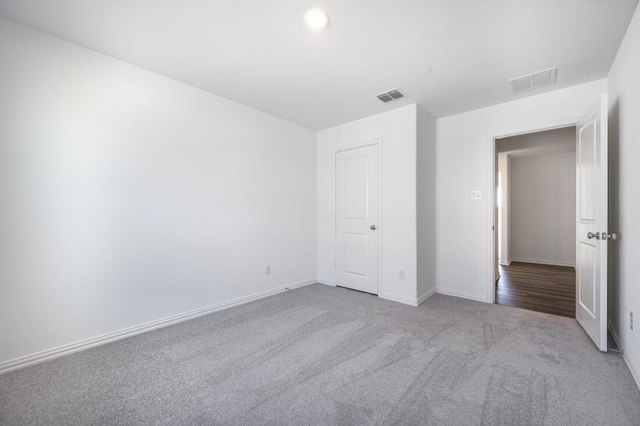 unfurnished bedroom with baseboards, carpet flooring, and visible vents