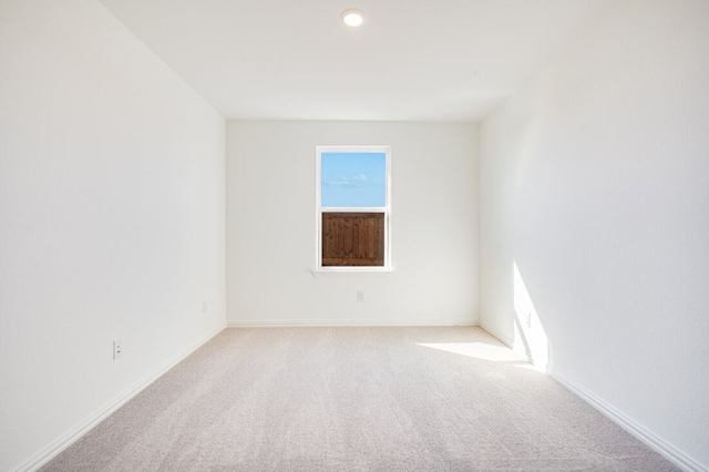 carpeted spare room featuring baseboards