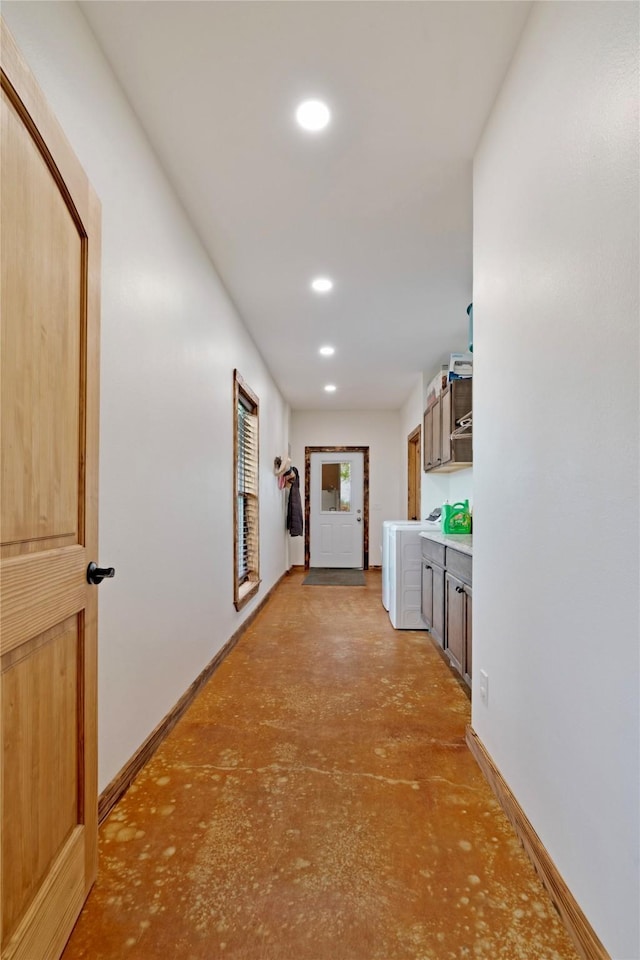 hall with baseboards, washer / clothes dryer, recessed lighting, and concrete flooring