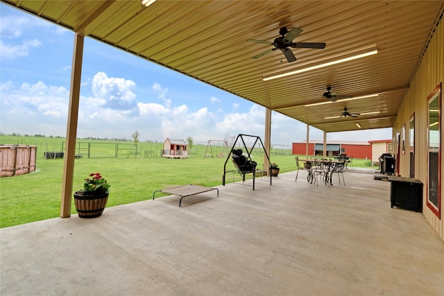 view of patio featuring a rural view, fence, outdoor dining space, and a ceiling fan