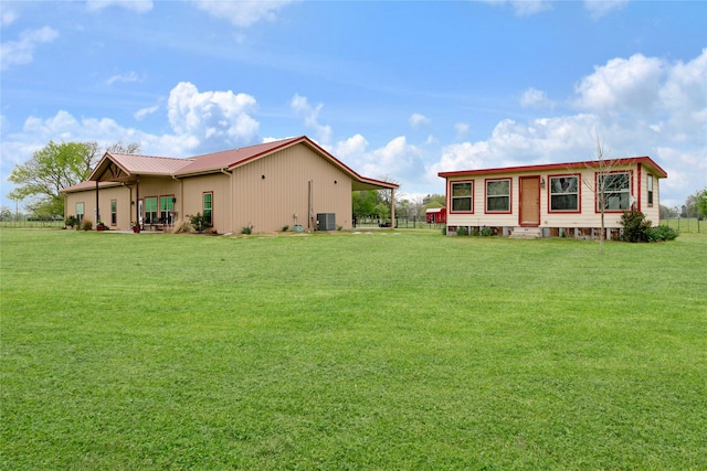back of property with central AC and a yard