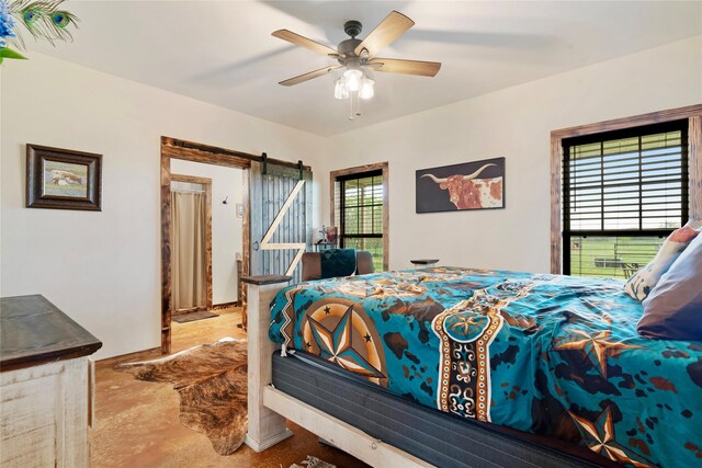 bedroom featuring a ceiling fan, concrete floors, and a barn door