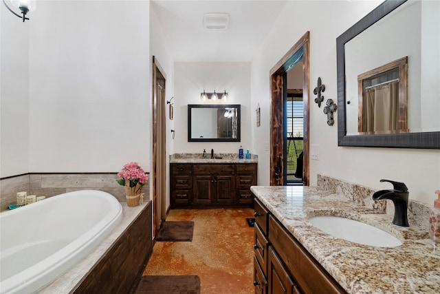 bathroom featuring two vanities, a sink, and a garden tub