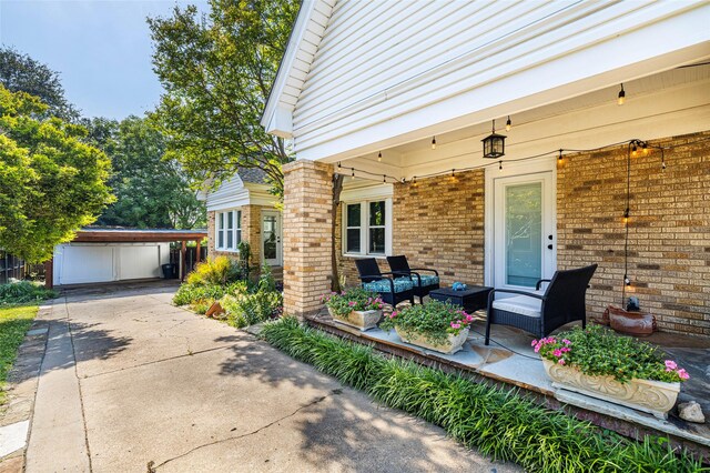 1936 Forest Park Blvd, Fort Worth, TX 76110 - view of exterior entry featuring brick siding, concrete driveway, a carport, and an outdoor living space