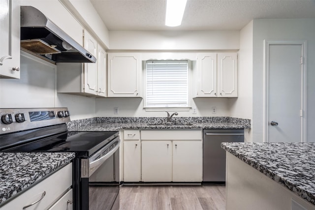 3100 E Park Blvd, Plano, TX 75074 - kitchen featuring appliances with stainless steel finishes, wall chimney exhaust hood, a sink, white cabinetry, and light wood-style flooring