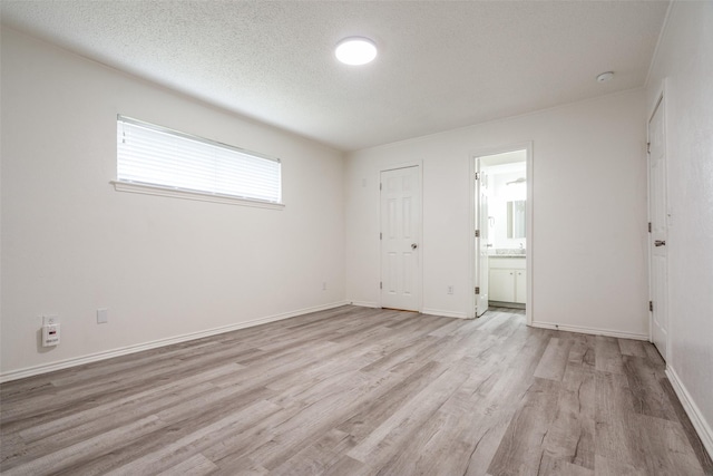 3100 E Park Blvd, Plano, TX 75074 - unfurnished bedroom with light wood finished floors, ensuite bath, a textured ceiling, and baseboards