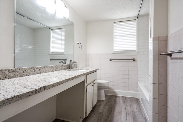 3100 E Park Blvd, Plano, TX 75074 - bathroom with tile walls, healthy amount of natural light, wood finished floors, vanity, and toilet
